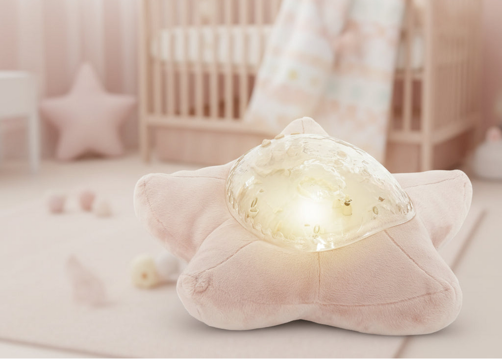 TinyBliss star-shaped plush toy with a glowing light in a soft pink room.
