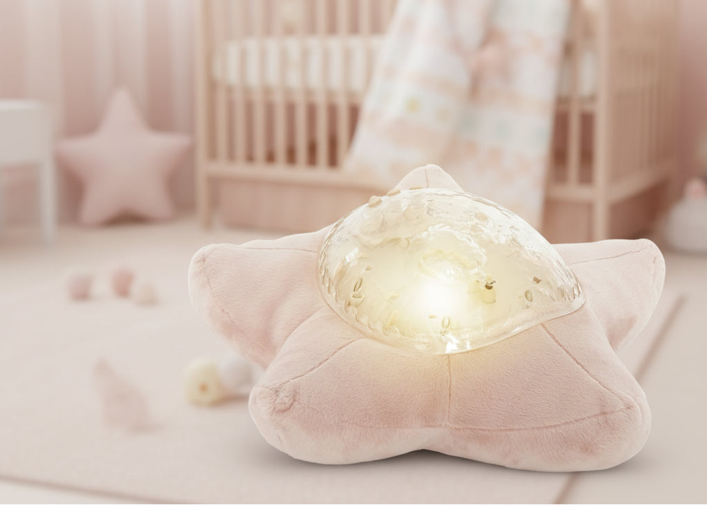 TinyBliss star-shaped plush toy with a glowing light in a soft pink room.